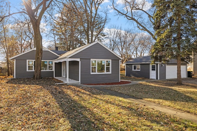 ranch-style home with a front yard, an outdoor structure, and a garage