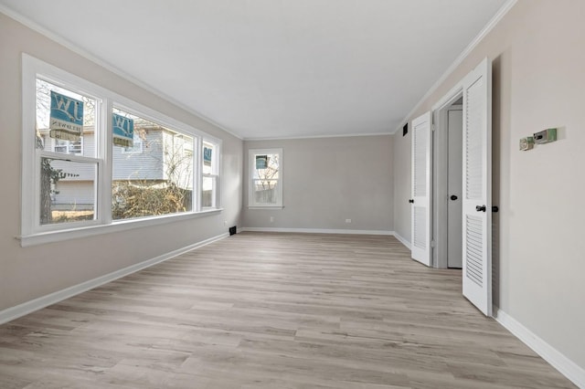 empty room featuring crown molding and light hardwood / wood-style floors