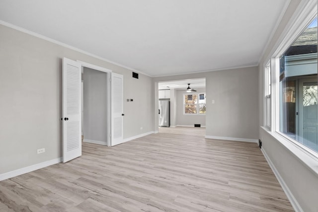 spare room featuring ceiling fan, crown molding, and light hardwood / wood-style flooring