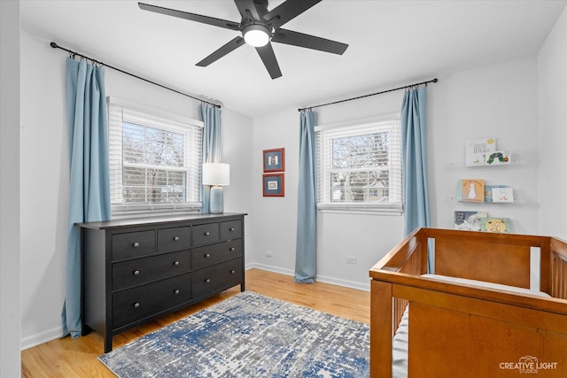 bedroom with light hardwood / wood-style floors, multiple windows, and ceiling fan