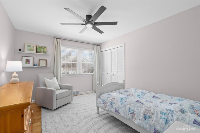 bedroom with ceiling fan, hardwood / wood-style flooring, and a closet