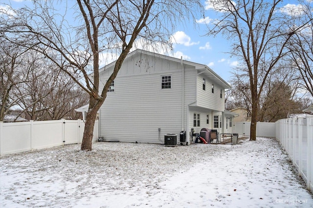 snow covered house with central AC unit