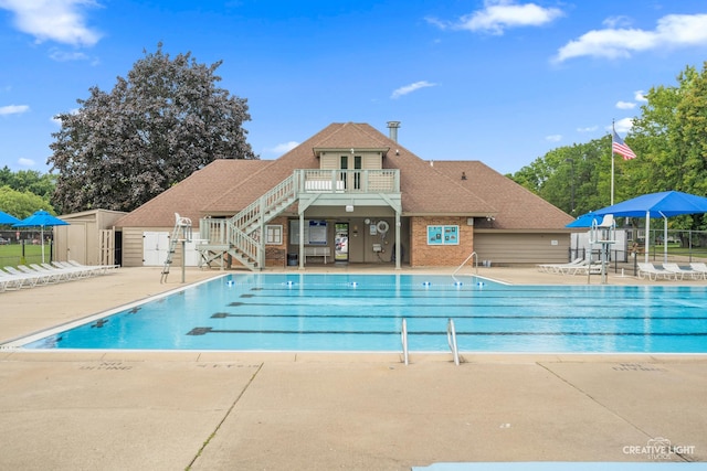 view of pool with a patio and a storage unit