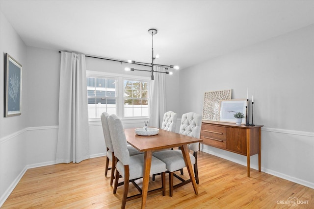 dining space with light wood-type flooring and a chandelier