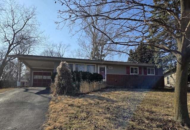 ranch-style house with a garage, brick siding, and driveway