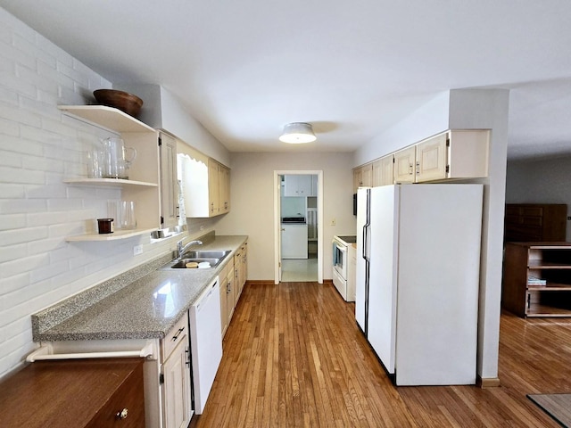 kitchen with a sink, open shelves, wood finished floors, white appliances, and baseboards