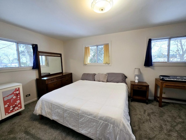 bedroom featuring dark colored carpet, baseboards, and multiple windows