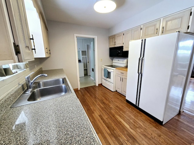 kitchen featuring white appliances, baseboards, a sink, dark wood-type flooring, and light countertops