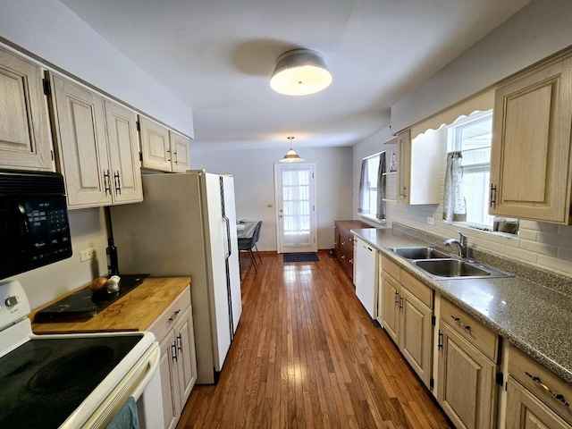 kitchen with white appliances, wood finished floors, light brown cabinets, a sink, and decorative backsplash