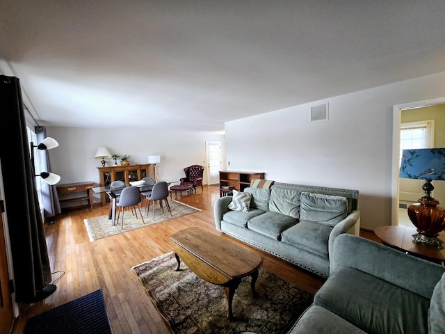 living room featuring visible vents and light wood-style flooring