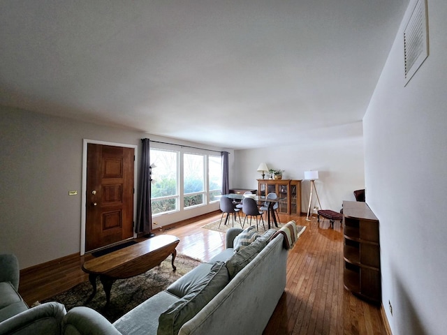 living area with dark wood-style floors and visible vents