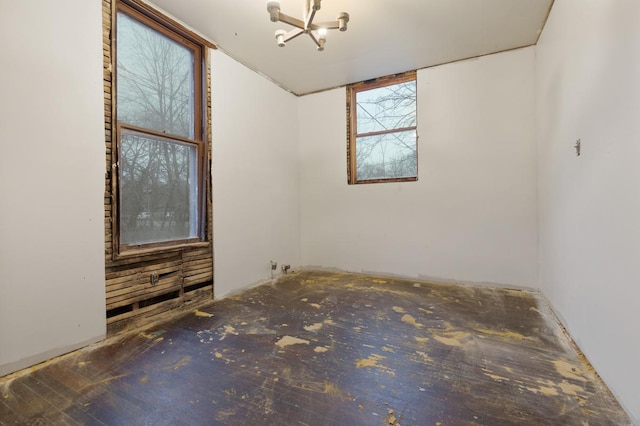 unfurnished room featuring a chandelier