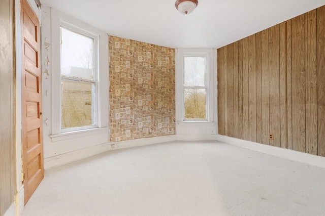 carpeted empty room with wood walls