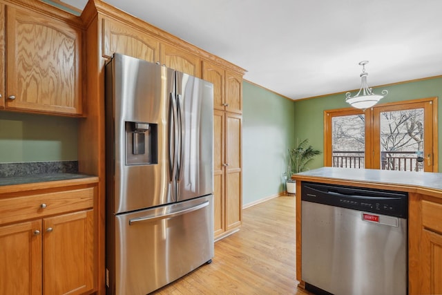 kitchen featuring stainless steel appliances, light hardwood / wood-style floors, and decorative light fixtures