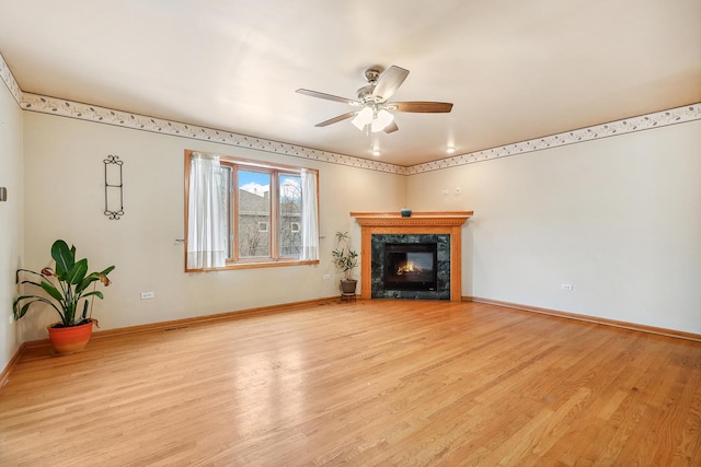 unfurnished living room with ceiling fan, a fireplace, and light hardwood / wood-style flooring