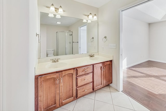 bathroom featuring tile patterned floors, walk in shower, toilet, and vanity