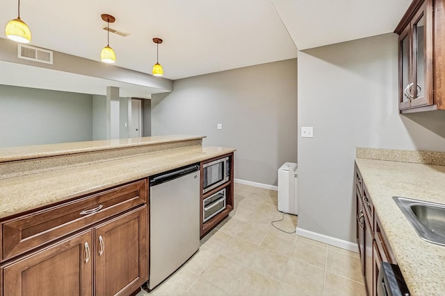 kitchen featuring light stone countertops, appliances with stainless steel finishes, sink, and pendant lighting