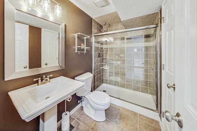 bathroom featuring toilet, tile patterned flooring, sink, a textured ceiling, and an enclosed shower