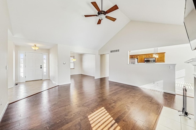 unfurnished living room with high vaulted ceiling, ceiling fan, and hardwood / wood-style flooring