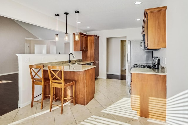 kitchen with decorative light fixtures, sink, kitchen peninsula, light tile patterned flooring, and a breakfast bar area