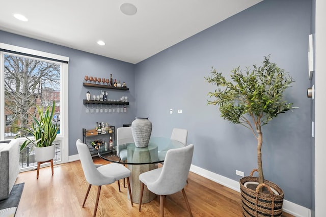 dining space featuring bar area and hardwood / wood-style floors