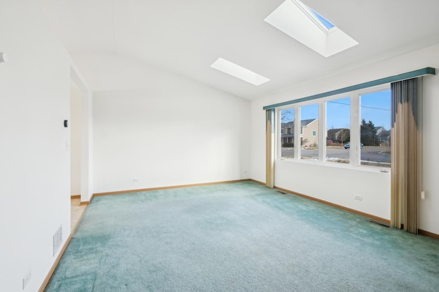 carpeted empty room with lofted ceiling with skylight