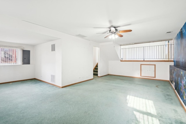 interior space with ceiling fan, light carpet, and electric panel