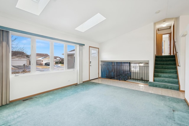 spare room with light colored carpet and lofted ceiling with skylight