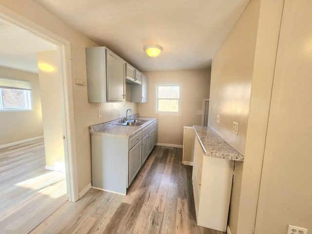 kitchen featuring light hardwood / wood-style floors, sink, and gray cabinets