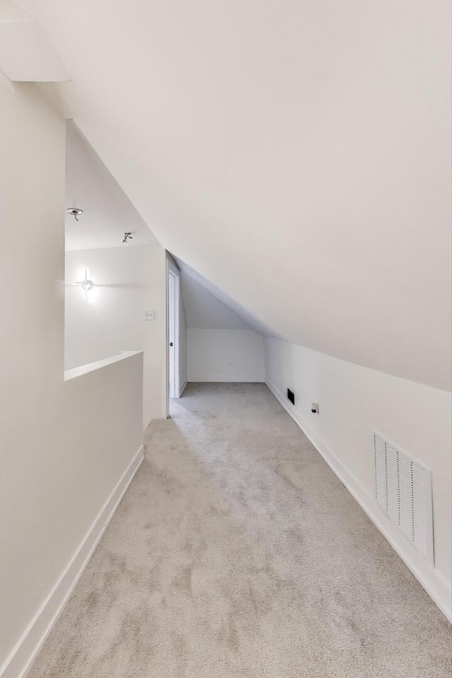 additional living space featuring lofted ceiling, carpet flooring, visible vents, and baseboards