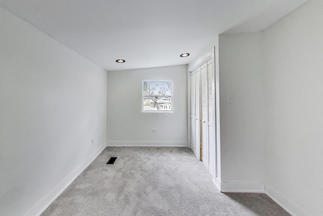 unfurnished bedroom featuring baseboards, carpet flooring, a closet, and visible vents