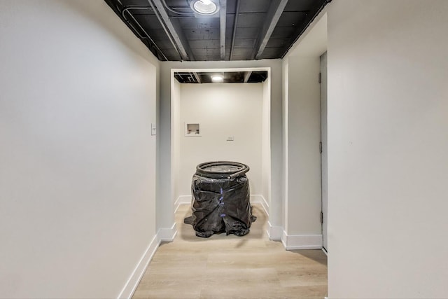 corridor featuring baseboards and wood finished floors