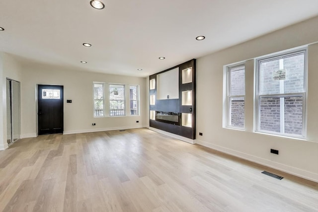 unfurnished living room featuring baseboards, recessed lighting, light wood finished floors, and visible vents
