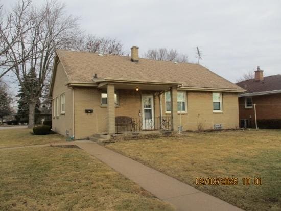 rear view of property featuring a lawn and a porch