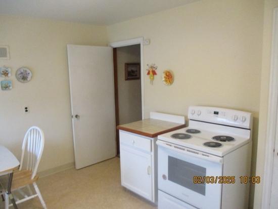 kitchen with white cabinetry and white electric range oven