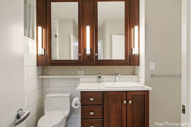 bathroom with toilet, decorative backsplash, and vanity