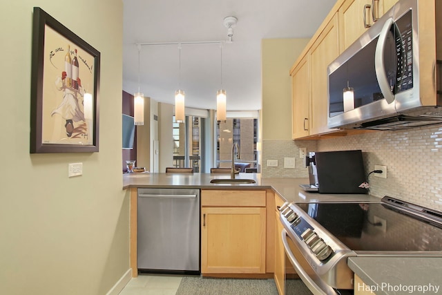 kitchen featuring tasteful backsplash, hanging light fixtures, sink, stainless steel appliances, and light brown cabinets