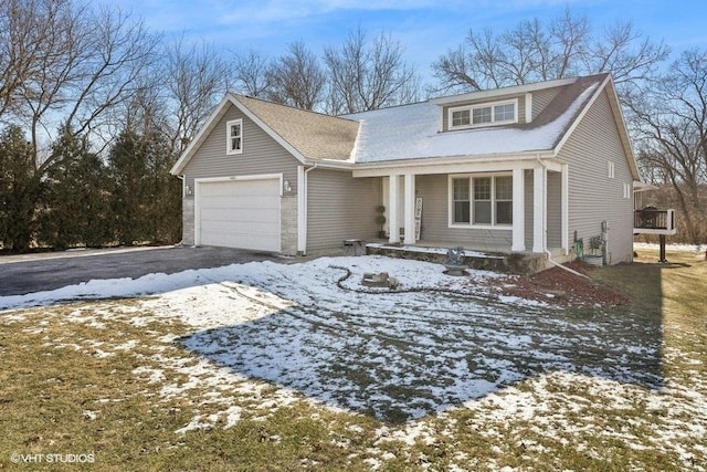 traditional home with a porch, driveway, and an attached garage