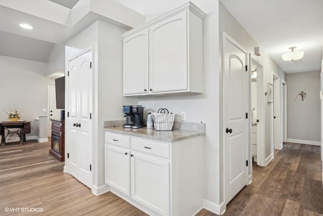 corridor featuring recessed lighting, light wood-style flooring, and baseboards