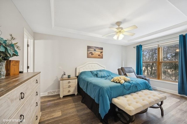 bedroom featuring visible vents, baseboards, a raised ceiling, and dark wood-type flooring