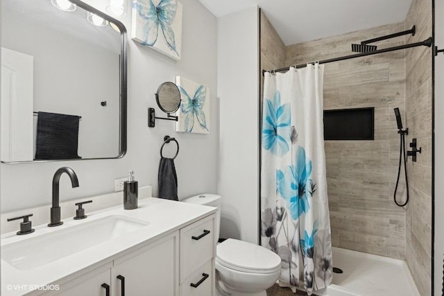 full bath featuring toilet, vanity, and a tile shower