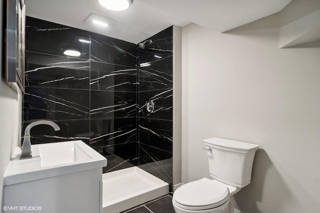 bathroom with tile patterned floors, toilet, tiled shower, and vanity