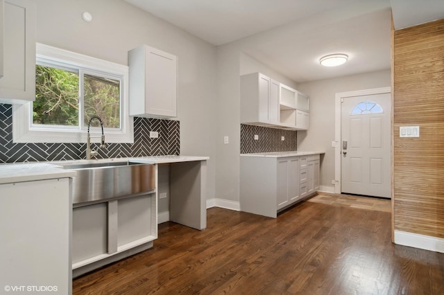 kitchen with white cabinets, decorative backsplash, dark hardwood / wood-style flooring, and sink