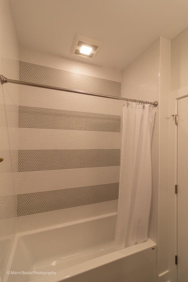 bathroom with shower / bath combo with shower curtain