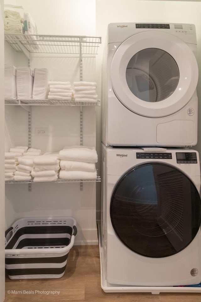 washroom featuring stacked washing maching and dryer and light hardwood / wood-style floors