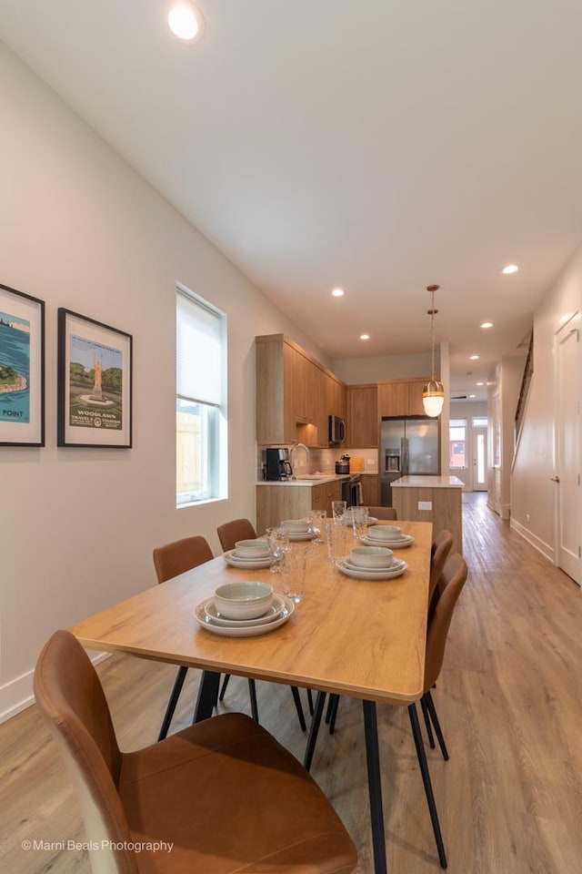 dining area featuring light wood-type flooring and a wealth of natural light