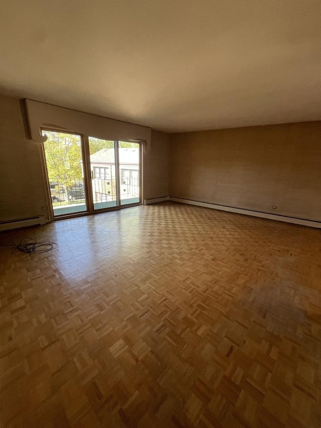 empty room featuring a baseboard heating unit and parquet flooring