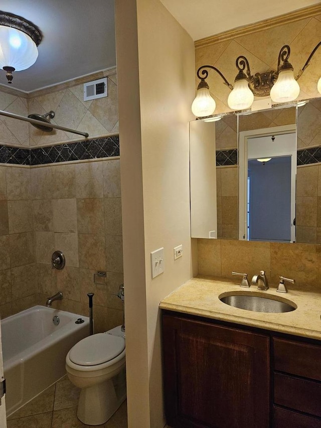 full bathroom featuring toilet, tiled shower / bath combo, tile patterned floors, and vanity