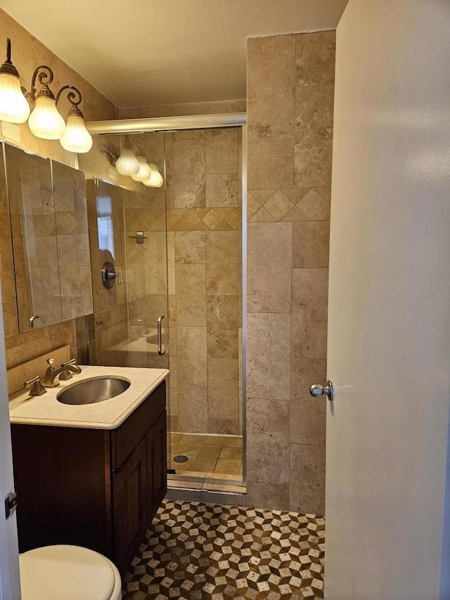 bathroom with a shower with shower door and vanity