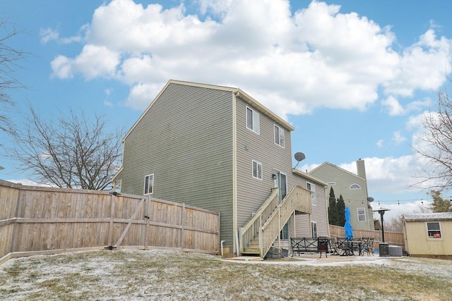 rear view of property with central AC